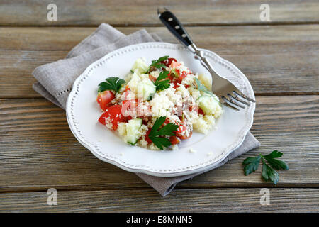 Frischer Salat mit Couscous und Gemüse auf einem weißen Teller, nahrhaftes Essen Stockfoto