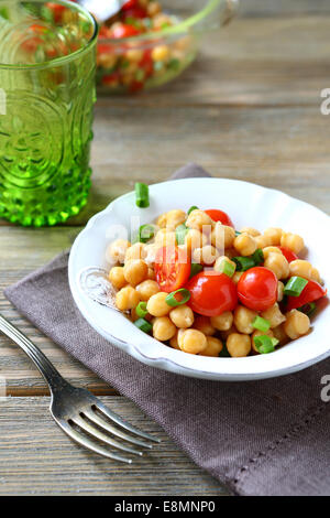 Salat mit gekochten Kichererbsen und Tomaten auf einer Serviette Stockfoto