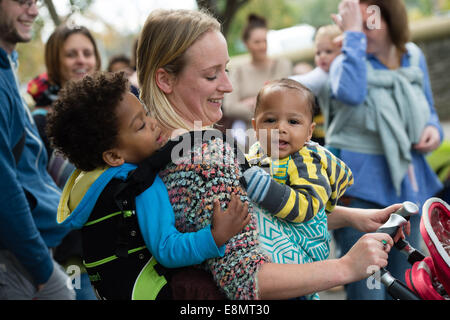 Aberystwyth Wales UK, Samstag, 11. Oktober 2014 Gruppe von Müttern mit ihren kleinen Kindern statt auf ihren Körper in Schlingen schließen treffen sich spazieren Gruppe am letzten Tag der internationalen Babytragen Week 2014. Nicht weit verbreitet durch moderne Industriegesellschaften, Babytragen fördert die Bindung, stillen unterstützt, helfen Kampf postpartale Depression und erleichtert die Pflege. Bildnachweis: Keith Morris/Alamy Live News Stockfoto