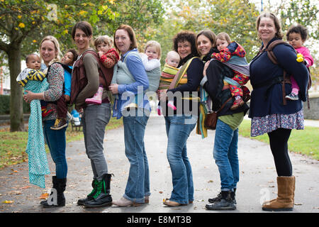 Aberystwyth Wales UK, Samstag, 11. Oktober 2014 Gruppe von Müttern mit ihren kleinen Kindern statt auf ihren Körper in Schlingen schließen treffen sich spazieren Gruppe am letzten Tag der internationalen Babytragen Week 2014. Nicht weit verbreitet durch moderne Industriegesellschaften, Babytragen fördert die Bindung, stillen unterstützt, helfen Kampf postpartale Depression und erleichtert die Pflege. Bildnachweis: Keith Morris/Alamy Live News Stockfoto