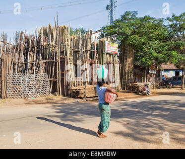 MADURAI-INDIEN MIT EINEM FARBIGEN WASSERTOPF AUF DEM KOPF BALANCIERT Stockfoto