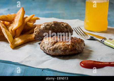 zwei Burguer auf Papier mit Pommes Frites und ketchup Stockfoto