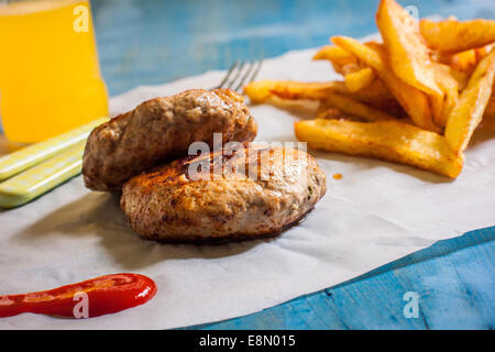 zwei Burguer auf Papier mit Pommes Frites und ketchup Stockfoto
