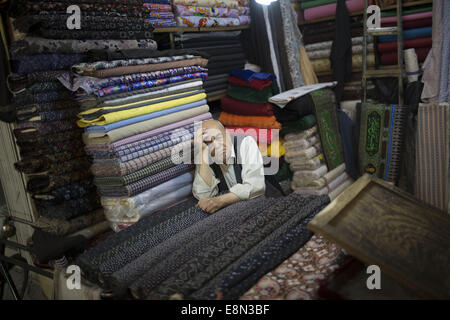 Isfahan, der Iran. 11. Oktober 2014. 11. Oktober 2014 - Isfahan, der Iran - eine iranische Händler schläft, wie er sitzen an seinem Tuch shop in Isfahan traditionelle Grand Bazaar, 450 km (281 Meilen) südlich von Teheran. Traditionellen Basar ist ein historischer Markt in der Stadt Isfahan auch einer der ältesten und größten Basare im Nahen Osten die bis ins 17. Jahrhundert zurückreicht, ist. Der Basar mit 2 Km Länge ist die Hauptverbindung zwischen der alten Stadt mit dem neuen. Morteza Nikoubazl/ZUMAPRESS © Morteza Nikoubazl/ZUMA Draht/Alamy Live-Nachrichten Stockfoto