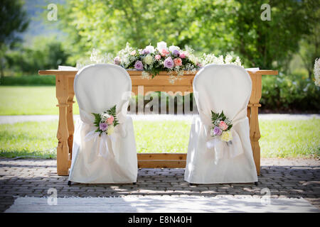 Hochzeit Stühle Abdeckungen mit frischen Rosen in einem Hochzeitstag Stockfoto