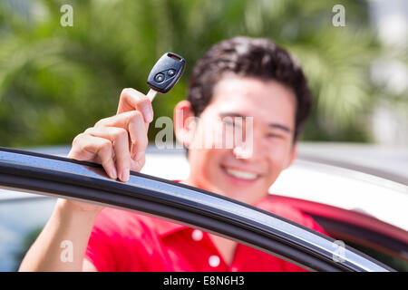 Asiatischer Mann zeigt Schlüssel seines neuen Autos Stockfoto