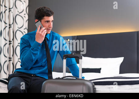 Geschäftsmann, Ankunft im Hotelzimmer mit Handy telefonieren Stockfoto