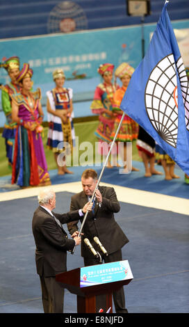 Nanning, China autonomen Region Guangxi Zhuang. 12. Oktober 2014. FIG-Präsident Bruno Grandi (L) übergibt die FIG-Flagge mit einem Vertreter von Glasgow, Scotland, UK, der Gastgeberstadt der 46. Gymnastik-Weltmeisterschaften, bei der Abschlussfeier der 45. Gymnastik-Weltmeisterschaften in Nanning, Hauptstadt von Süd-China Autonome Region Guangxi Zhuang, 12. Oktober 2014. Bildnachweis: Huang Xiaobang/Xinhua/Alamy Live-Nachrichten Stockfoto