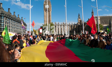 Parliament Square, London UK. 11. Oktober 2014.  Kurdische Volk versammeln sich in Parliament Square in demonstrieren gegen die überwältigende Aggression der ISIS, mangelnde Unterstützung beim Schutz der Kurden in der Stadt Kobane in Syrien und Welle anti-türkischen AKP-Regierung-Plakate. Frauen und Kinder halten eine Banner mit Farben der kurdischen Flagge, ihre Solidarität zu zeigen, bei der Bekämpfung des islamischen Staates. Kathy DeWitt/Alamy Live-Nachrichten Stockfoto