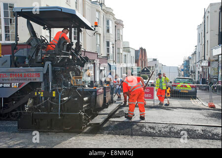 Eine Caterpiller Straßenfertiger auftauchen taucht eine Hauptstraße in Brighton East Sussex Stockfoto