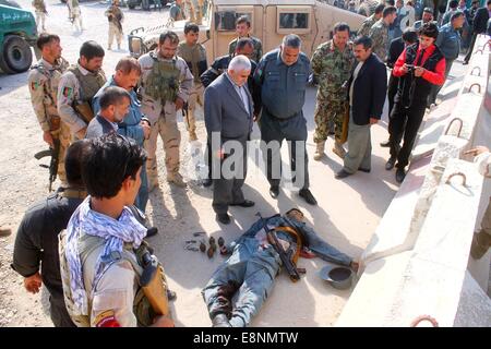 (141012)--MAZAR-I-SHARIF, 12. Oktober 2014 (Xinhua)--Menschen versammeln sich um den Körper eines Terroristen nach einem Angriff in Mazar-i-Sharif Stadt, der Provinz Balkh, Nordafghanistan, am 12. Oktober 2014. Etwa 18 Polizisten wurden verletzt, nachdem zwei Militante tragen Polizei eröffneten das Feuer im Inneren der Provinz Polizeipräsidium in Mazar-i-Sharif Stadt, Hauptstadt der Nordprovinz afghanischen Balkh am Sonntag, einheitliche Quellen sagten. (Xinhua/Azorda) (Zhf) Stockfoto