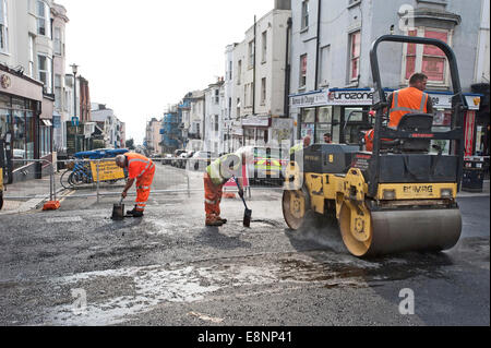 Bild von Roger Bamber: 23. September 2014: eine Dampfwalze drückt die Schnitzel aus der Häcksler in den frisch gelegten Asphalt Stockfoto