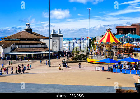 Die attraktive Annäherung an Bournemouth Pier mit eindrucksvollen Gebäuden, bunten Vordächer über die Kirmes Fahrgeschäfte und café Stockfoto