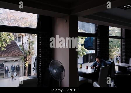 Ein Mann sitzt in einem Restaurant an der Hauptstadt Stadt Pristina im Kosovo Stockfoto