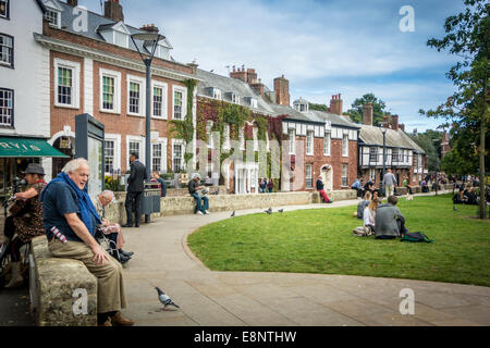 Häuser in Cathedral Close mit Menschen sitzen auf gegenüberliegenden The Green Stockfoto