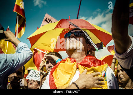 Barcelona, Spanien. 12. Oktober 2014. Ein Demonstrator in der spanischen Flagge gehüllt hört die Hymne während einer Protestaktion für die Einheit von Spanien am Columbus Day, nationaler Tag von Spanien in Barcelona. © Matthias Oesterle/ZUMA Draht/Alamy Live-Nachrichten Stockfoto