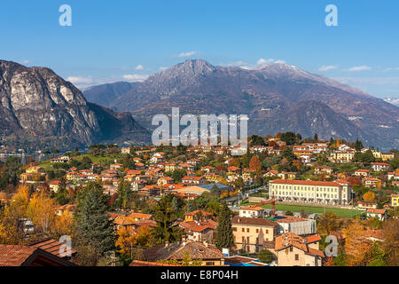 Blick auf kleine Stadt umgeben von Bergen am Ufer des Comer Sees im Herbst in Italien. Stockfoto