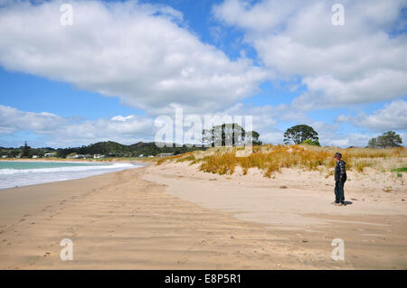 Einsamer Mann am Sandstrand in Matapouri Bay bei Ebbe Stockfoto