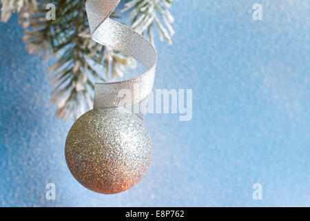 Weihnachtskugel Tannenzweigen und verschneiten blauen Hintergrund closeup Stockfoto