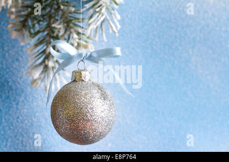 Weihnachtskugel Tannenzweigen und verschneiten blauen Hintergrund closeup Stockfoto