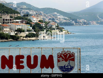 "Neum" und das Emblem der Stadt, vor der Kulisse der Stadt Neum in Bosnien und Herzegowina, Zugang zum Adriatischen Meer des Staates, am 10. September 2014. Stockfoto