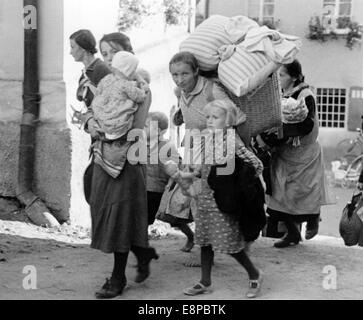 Das Bild aus einem Nazi-Nachrichtenbericht zeigt, dass Sudetens deutsche Frauen und Kinder, die aus der Tschechoslowakei geflohen sind, in einer deutschen Grenzstadt ankommen, deren Ort im September 1938 unbekannt war. Der ursprüngliche Propagandatext der Nazis lautet: "Bauern aus dem böhmischen Wald kommen von der Bande in deutschen Grenzstädten mit ihren Kindern und ihren wichtigsten Gegenständen auf dem Rücken an. Fotoarchiv für Zeitgeschichtee - KEIN KABELDIENST Stockfoto