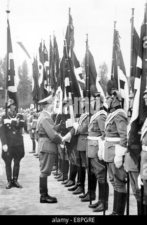 Nürnberger Rallye 1937 in Nürnberg - Beschneidung der Flaggen der deutschen Polizei durch Adolf Hitler auf Deutschherrnwiese in Nürnberg am 10. September 1937. Originaler Propagandatext! Aus den Nachrichten der Nazis auf der Rückseite des Bildes: "Der Führer weiht 23 neue Flaggen der deutschen Polizei auf Deutschherrnwiese. Er begrüßte jeden Kommandanten, berührte die Flagge mit der Hand, woraufhin die Flagge als geweiht hing. Der Überbringer der Blutflagge [Jakob Grimminger] folgt dem Führer. (Qualitätsmängel aufgrund der historischen Bildkopie) Fotoarchiv für Zeitgeschichtee – KEIN KABELDIENST – Stockfoto