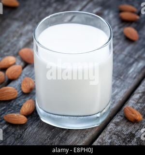 Mandelmilch, Nüssen und Glas lecker Milch auf alten Holztisch Stockfoto