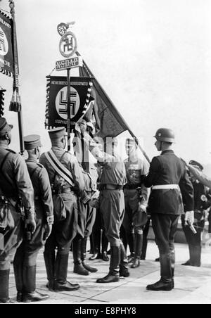 Nürnberger Rallye 1938 in Nürnberg – die neuen Standards werden von Adolf Hitler mit der „Blutflagge“, hinter Hitler, dem Standardträger Jakob Grimminger, geweiht. Während der Weihung der Flaggen wurden neue Standards der Sturmabteilung (SA) und Schutzstaffel (SS) mit der "Blutflagge" in Berührung gebracht, die angeblich während der gescheiterten Bierhalle Putsch getragen und damit geweiht wurde. (Qualitätsmängel aufgrund der historischen Bildkopie) Fotoarchiv für Zeitgeschichtee - KEIN KABELDIENST - Stockfoto