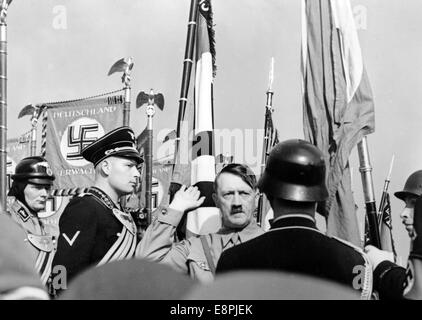 Reichsparteitag in Nürnberg, Deutschland - die neuen Normen sind durch Adolf Hitler mit dem Blut Flagge während der Appell der Sturmabteilung (SA), Schutzstaffel (SS), nationale sozialistische Motor-Korps (NSKK) und nationalen sozialistischen Flyer Corps (NSFK) bei Röhms, auf der rechten Seite der Fahnenträger Jakob Grimminger geweiht. Während der Einweihung der Fahnen neuen Standards der Sturmabteilung (SA) geweiht Und, die Schutzstaffel (SS) waren berührt, die Blut-Flagge, die angeblich während der gescheiterten Bier Hall Putsch, und dadurch vollzogen wurde. (Mängel in der Qualität durch das historische Bild kopieren Stockfoto