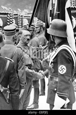 Nürnberger Rallye 1937 in Nürnberg – Adolf Hitler weiht die neuen Standards SA (Sturmabteilung), SS (Schutzstaffel) und NSKK (Nationales sozialistisches Kfz-Korps) mit der "Blutflagge" ein. Die neuen Standards werden von der "Blutflagge" (hinter Hitler) berührt, die angeblich während der Bierhalle Putsch getragen und damit geweiht wurde. Fotoarchiv für Zeitgeschichtee - KEINE ÜBERWEISUNG - Stockfoto