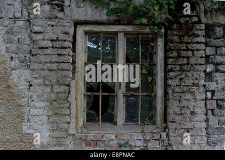 Fenster in einer verfallenen Mauer eines alten Hauses Stockfoto