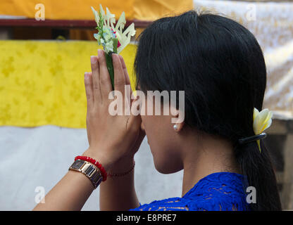 Frau mit Blume in gefalteten Händen Tempel Ubud Bali Indonesien beten Stockfoto