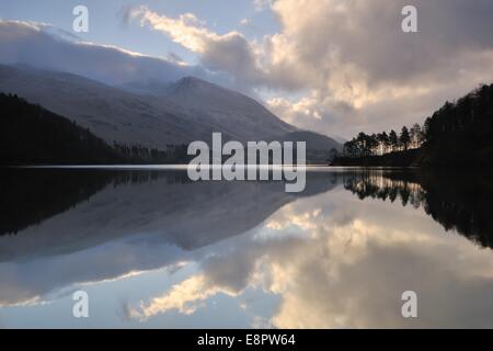 Kurz nach Sonnenaufgang zündete es Wolken durch die tief stehender Sonne zu reflektieren, in das Stille Wasser eines Sees in der Nähe von Keswick im Lake District. Stockfoto