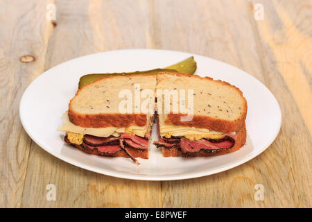 Pastrami Sandwich auf jüdische Roggenbrot mit Schweizer Käse, Senf und koscher Dill pickles Stockfoto