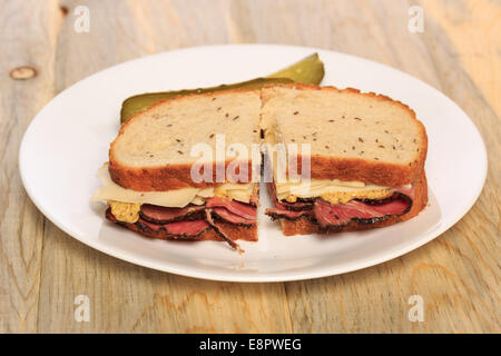 Pastrami Sandwich auf jüdische Roggenbrot mit Schweizer Käse, Senf und koscher Dill pickles Stockfoto