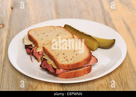 Pastrami Sandwich auf jüdische Roggenbrot mit Schweizer Käse, Senf und koscher Dill pickles Stockfoto