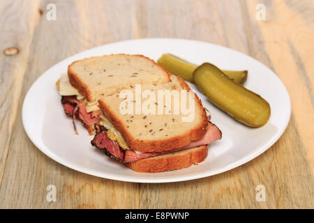 Pastrami Sandwich auf jüdische Roggenbrot mit Schweizer Käse, Senf und koscher Dill pickles Stockfoto