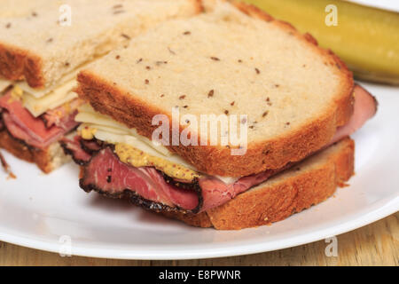 Pastrami Sandwich auf jüdische Roggenbrot mit Schweizer Käse, Senf und koscher Dill pickles Stockfoto