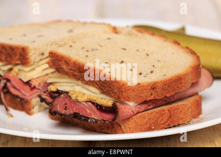 Pastrami Sandwich auf jüdische Roggenbrot mit Schweizer Käse, Senf und koscher Dill pickles Stockfoto