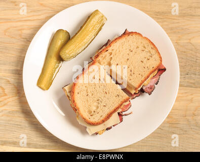 Pastrami Sandwich auf jüdische Roggenbrot mit Schweizer Käse, Senf und koscher Dill pickles Stockfoto