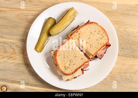 Pastrami Sandwich auf jüdische Roggenbrot mit Schweizer Käse, Senf und koscher Dill pickles Stockfoto