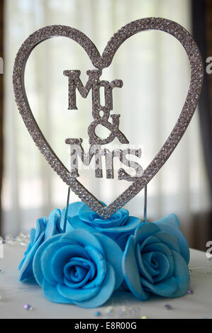 Herr und Frau Kuchen Dekoration auf einem blau-weißen Hochzeit Kuchen sitzen. Stockfoto