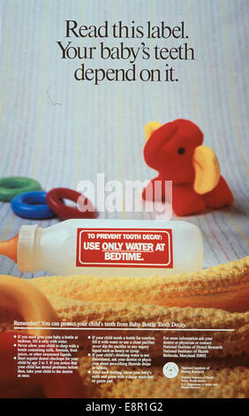 Dieses farbenfrohe Poster vom National Institute of Dental Research unterstreicht die Bedeutung der Mundhygiene für Säuglinge. Das Bild zeigt eine Babyflasche, umgeben von Zahnringen und einem Spielzeugelefanten, mit Ratschlägen zur Zahnpflege für Babys. Stockfoto