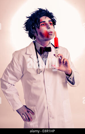 eine gruselige Zombie Arzt mit einer Spritze mit Blut, mit einem Filter-Effekt Stockfoto