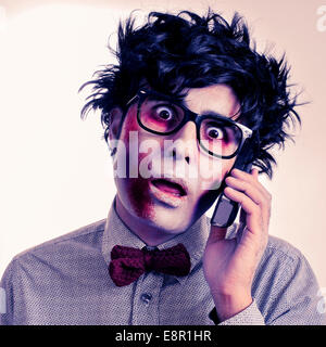 ein beängstigend Hipster-Zombie mit schwarzen Kunststoff-umrandeten Brille das Telefonieren mit einem Retro-Effekt Stockfoto