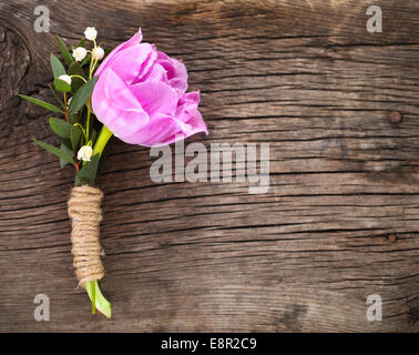 Lila Tulpe Knopfloch für den Bräutigam auf dem hölzernen Hintergrund. Nahaufnahme Stockfoto