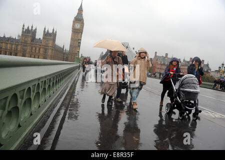 London, UK. 13. Oktober 2014.  UK-Wetter: Familie kreuzt Westminster Bridge vor Big Ben an einem regnerischen Tag in London Credit: JOHNNY ARMSTEAD/Alamy Live News Stockfoto