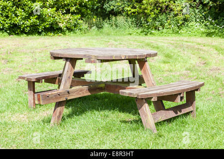 Runde Holz- Picknick Tisch und Sitzgelegenheiten auf Gras in einem Land Park, Nottinghamshire, England, Großbritannien Stockfoto