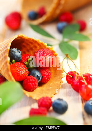 Wafer-Tassen mit Erdbeere, Kirsche, Himbeere und Heidelbeere. Dessert Stockfoto